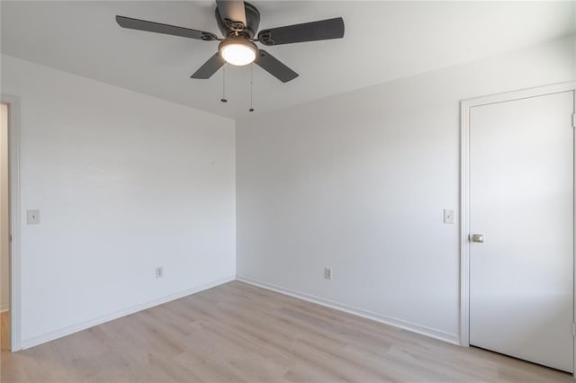 unfurnished room featuring a ceiling fan, light wood-type flooring, and baseboards