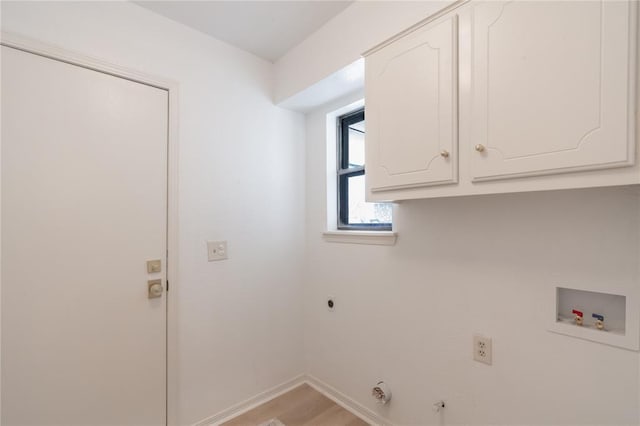 clothes washing area featuring baseboards, light wood-type flooring, hookup for a washing machine, cabinet space, and hookup for an electric dryer