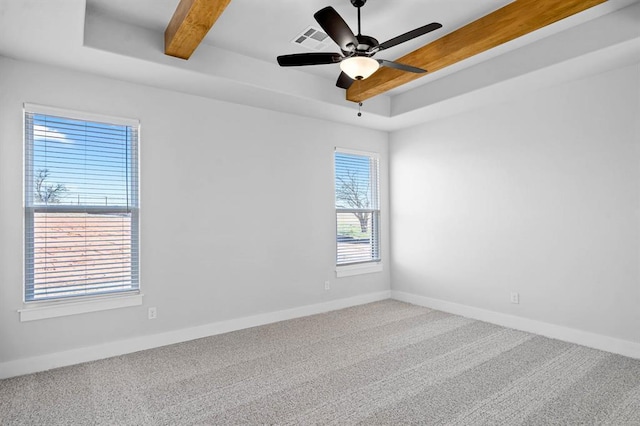 unfurnished room with visible vents, beam ceiling, baseboards, carpet, and a raised ceiling