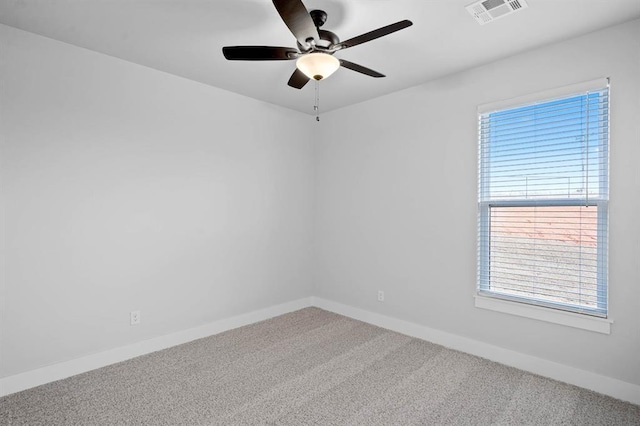 spare room with visible vents, carpet flooring, baseboards, and ceiling fan