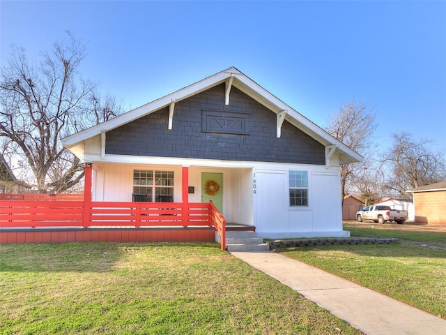 bungalow-style home featuring a front lawn and covered porch