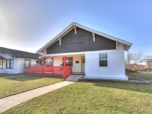 bungalow featuring a porch and a front lawn