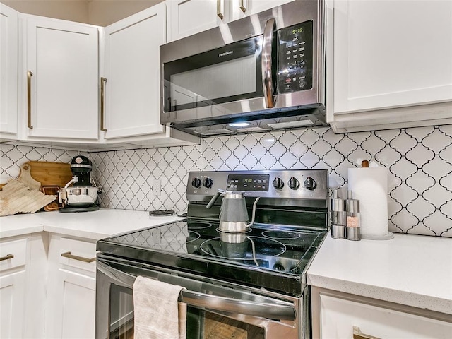 kitchen featuring decorative backsplash, light countertops, white cabinets, and appliances with stainless steel finishes