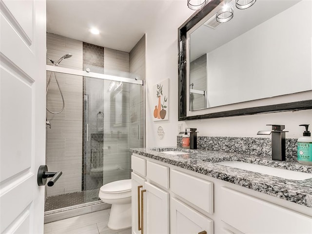 full bath featuring toilet, a stall shower, and a sink