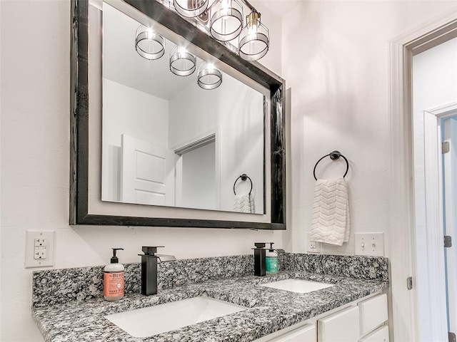 bathroom featuring a sink, an inviting chandelier, and double vanity