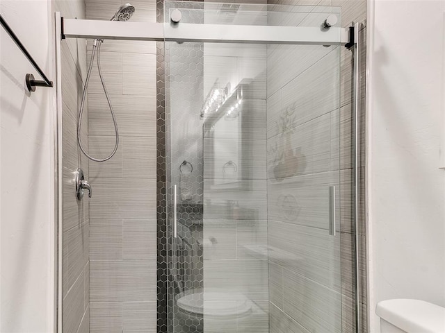 bathroom with a stall shower and toilet