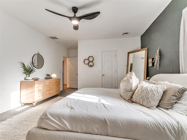 bedroom with visible vents, light colored carpet, and a ceiling fan