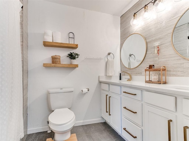 full bath with double vanity, toilet, baseboards, and a sink