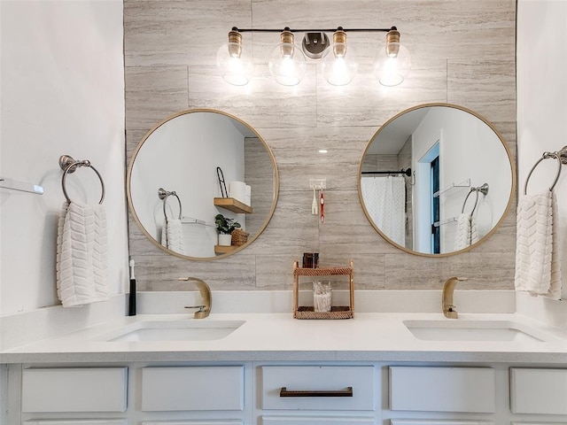 full bathroom featuring double vanity, backsplash, and a sink