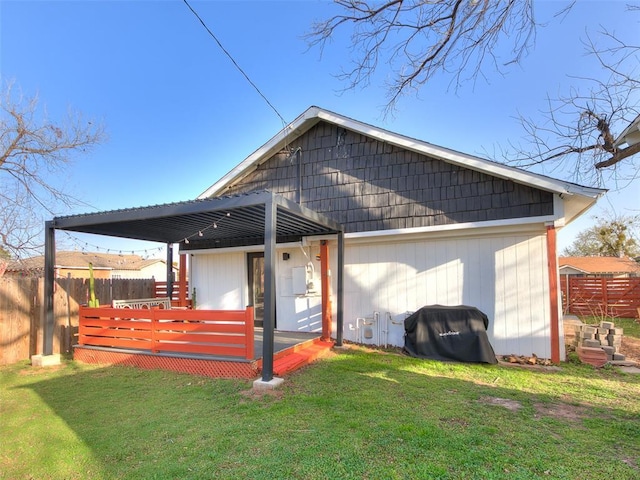 exterior space with a wooden deck, a lawn, and fence