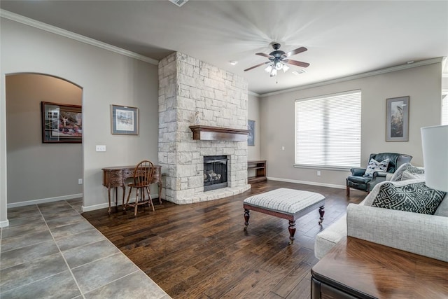 living area featuring baseboards, wood finished floors, a ceiling fan, and ornamental molding