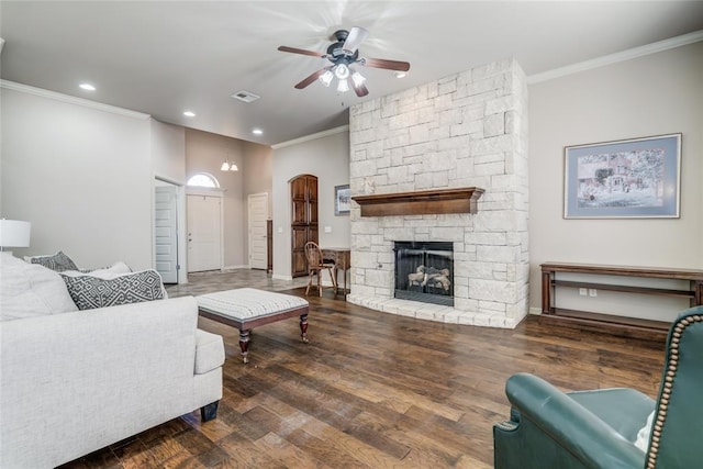 living area with ornamental molding, wood finished floors, visible vents, and ceiling fan