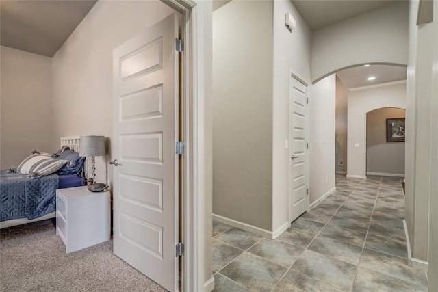 hallway featuring recessed lighting, baseboards, and arched walkways