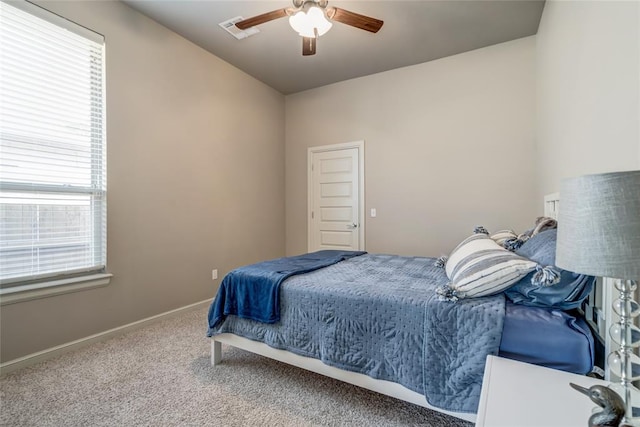 carpeted bedroom with visible vents, a ceiling fan, and baseboards