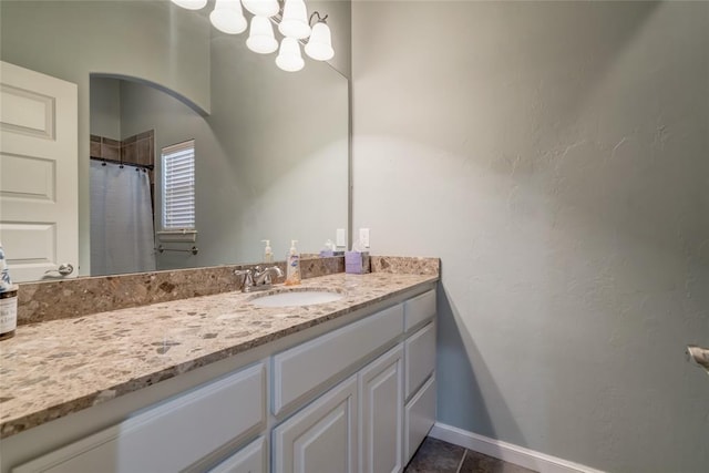 full bath featuring vanity, baseboards, tile patterned flooring, and a chandelier