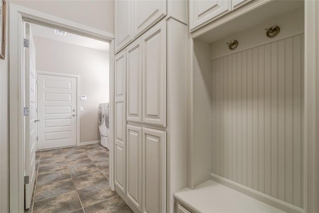 mudroom with baseboards, visible vents, and washer and clothes dryer