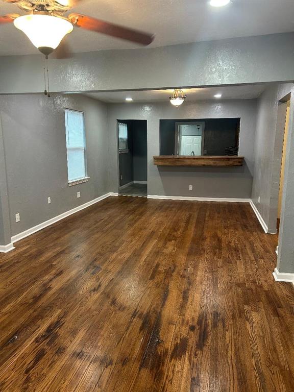 unfurnished room featuring wood finished floors, ceiling fan, and baseboards