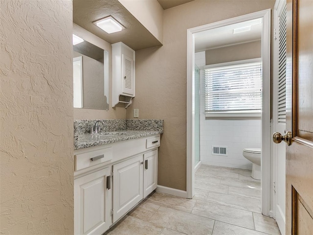5700 N Billen Ave, Oklahoma City, OK 73112 - full bathroom with vanity, visible vents, walk in shower, toilet, and a textured wall