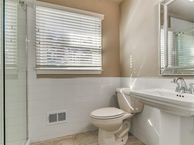 5700 N Billen Ave, Oklahoma City, OK 73112 - bathroom with visible vents, toilet, wainscoting, tiled shower, and tile walls