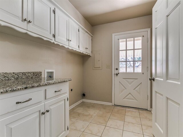 5700 N Billen Ave, Oklahoma City, OK 73112 - clothes washing area with electric dryer hookup, cabinet space, light tile patterned flooring, baseboards, and hookup for a washing machine
