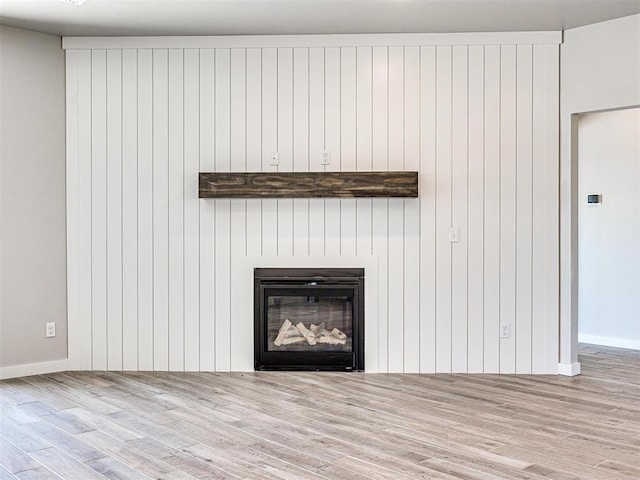 interior details featuring a glass covered fireplace and wood finished floors