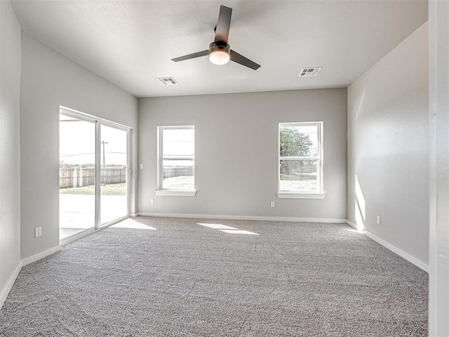 unfurnished room featuring baseboards, visible vents, carpet floors, and ceiling fan