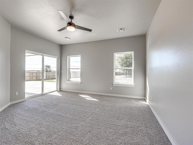 unfurnished room with baseboards, carpet, visible vents, and ceiling fan