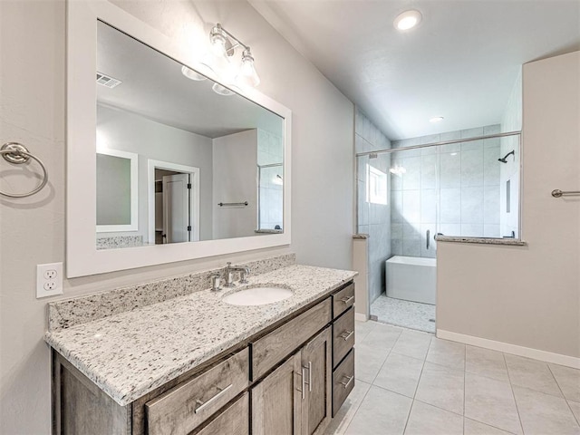 bathroom featuring vanity, visible vents, baseboards, tiled shower, and tile patterned flooring