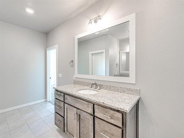 bathroom with vanity, baseboards, and tile patterned flooring