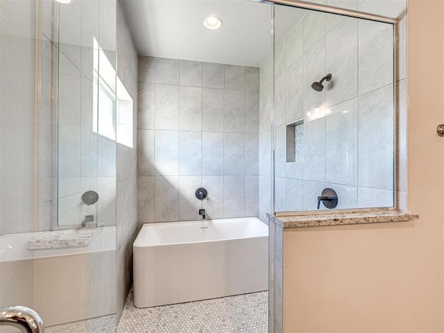 bathroom featuring tile patterned flooring, a garden tub, tile walls, and tiled shower