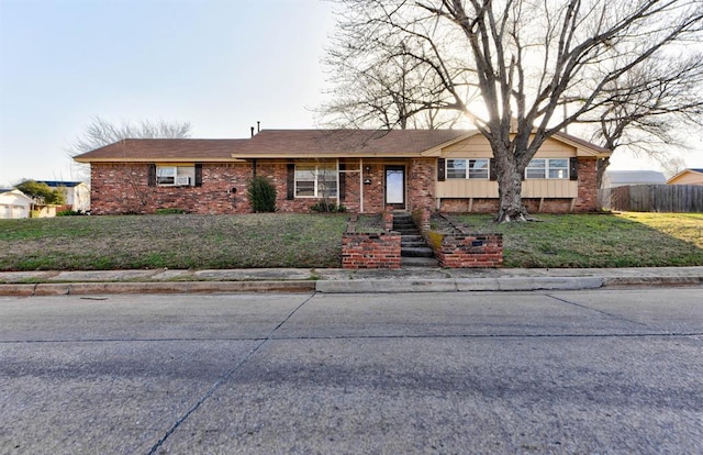 ranch-style home with brick siding, a front yard, and fence