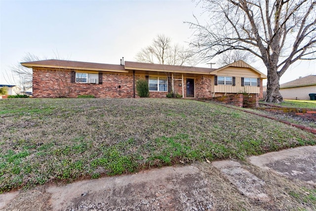 single story home featuring a front yard and brick siding