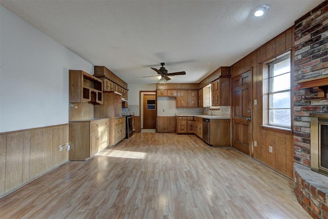 kitchen featuring a wainscoted wall, brown cabinets, open shelves, stainless steel appliances, and a fireplace