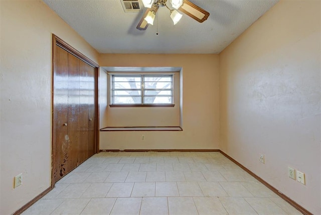 empty room featuring visible vents, baseboards, a textured ceiling, and ceiling fan