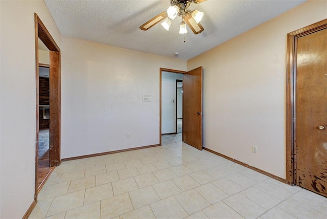 empty room featuring baseboards, a textured ceiling, and ceiling fan