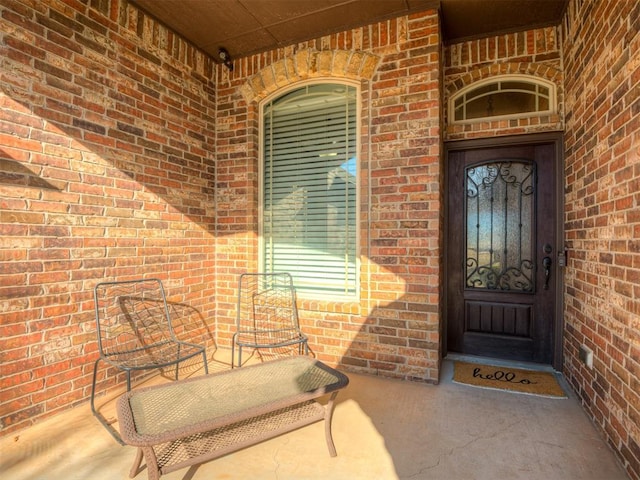 view of exterior entry featuring brick siding