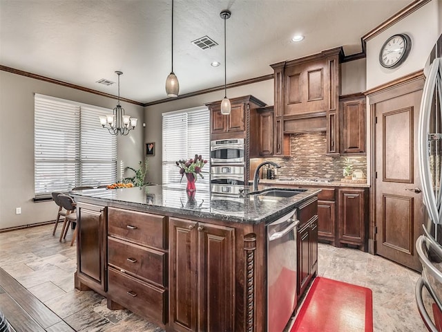 kitchen featuring visible vents, backsplash, an inviting chandelier, stainless steel appliances, and a sink