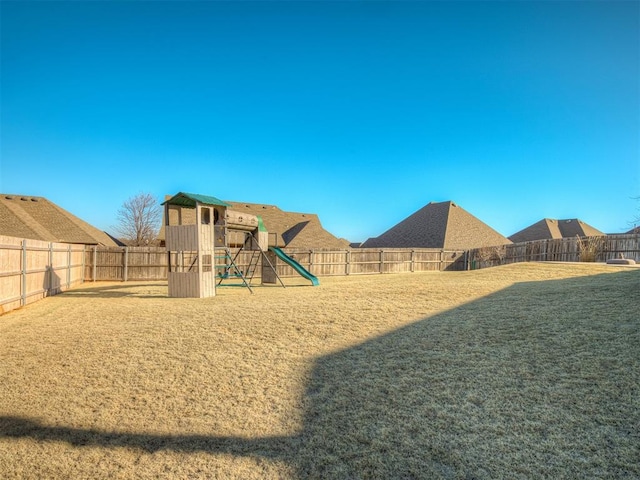 view of yard with a playground and a fenced backyard