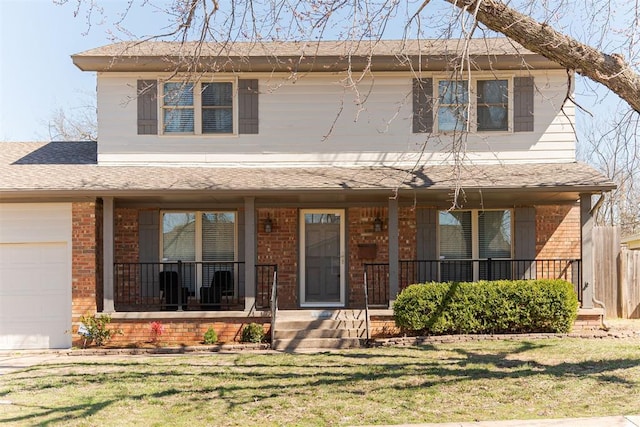 view of front of house featuring brick siding, covered porch, an attached garage, and a front yard