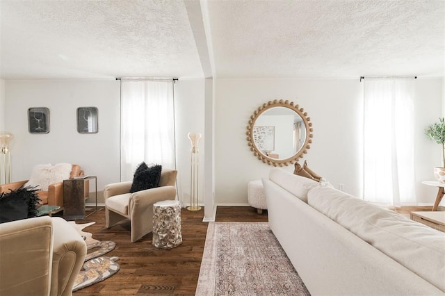 living room with plenty of natural light, dark wood-style flooring, and a textured ceiling