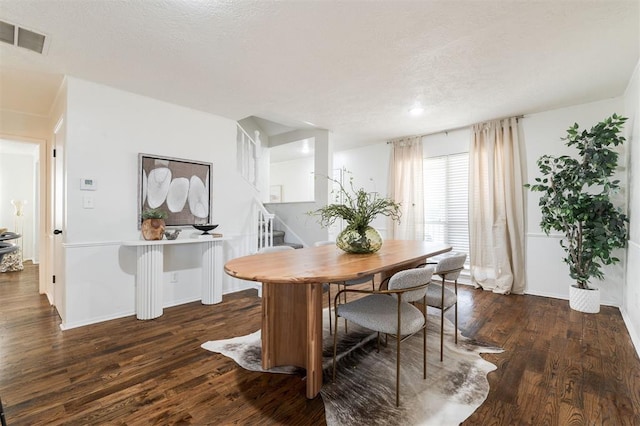 dining room featuring visible vents, baseboards, stairway, wood finished floors, and a textured ceiling