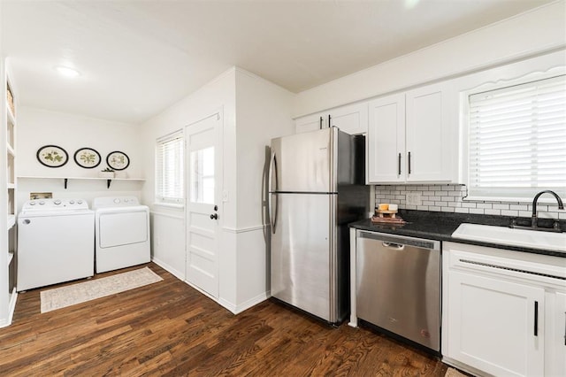 kitchen with a sink, dark wood-style flooring, stainless steel appliances, and separate washer and dryer