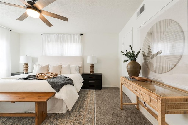 carpeted bedroom featuring baseboards, visible vents, a textured ceiling, and a ceiling fan