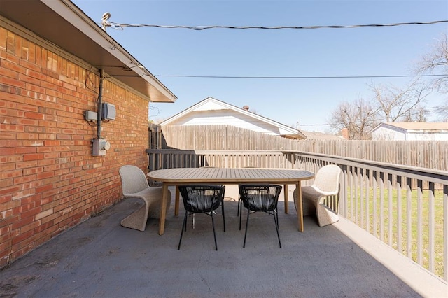 view of patio featuring outdoor dining space and fence