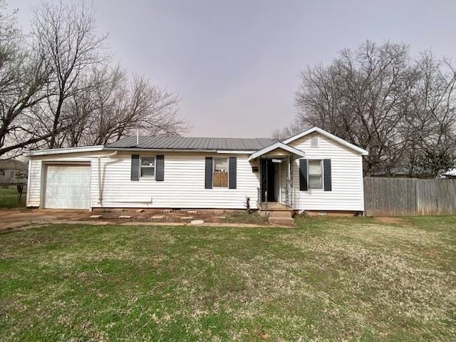 ranch-style house with metal roof, a front yard, and fence