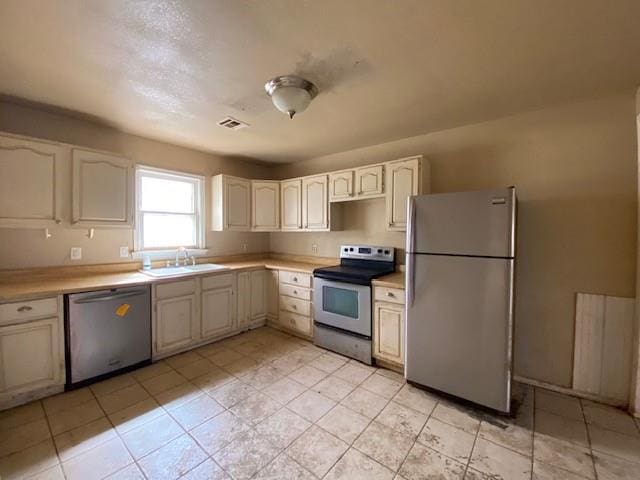 kitchen featuring visible vents, appliances with stainless steel finishes, light countertops, and a sink