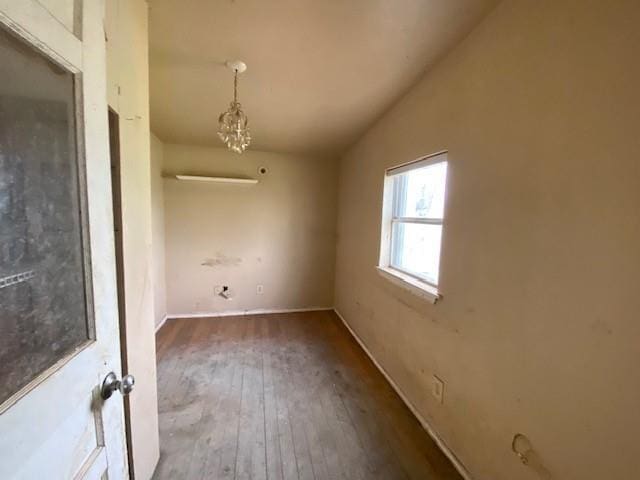 unfurnished room featuring lofted ceiling and hardwood / wood-style floors