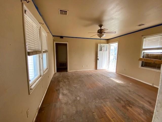 empty room featuring visible vents, baseboards, ceiling fan, and wood finished floors