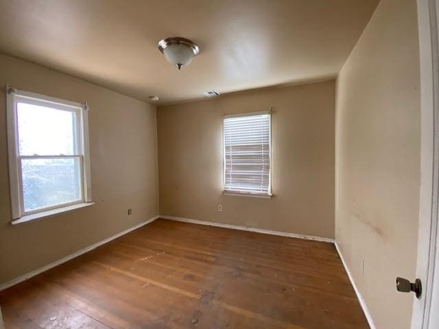 empty room featuring baseboards and wood finished floors