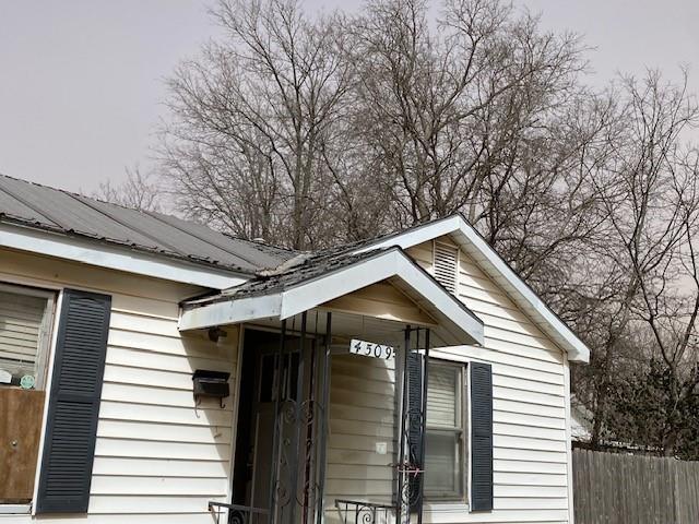 exterior space with metal roof and fence